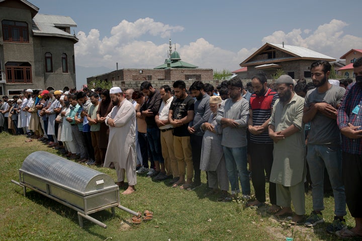 Relatives and neighbors offer prayers near the coffin of civilian Bashir Ahmed Khan, during his funeral on the outskirts of Srinagar on July 1, 2020.