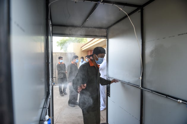 A worker walks through a disinfecting tunnel before entering a factory in Vasna Buzarg village, some...