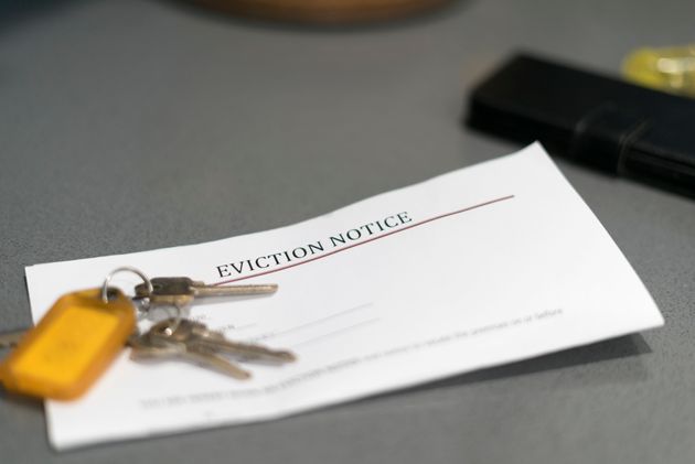 House keys sitting on an eviction notice received in the mail.