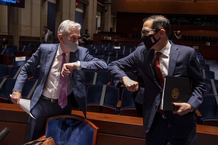 Federal Reserve Chairman Jerome Powell (left) and Treasury Secretary Steven Mnuchin bump elbows at the conclusion of a June 30 House Committee on Financial Services hearing on the pandemic response.