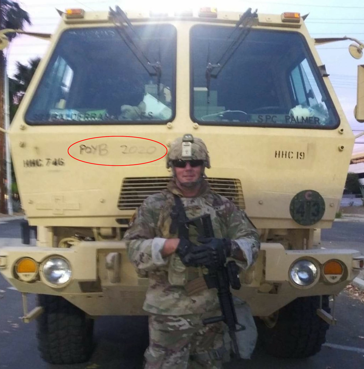 Sgt. Brian Jackson of the California National Guard posted this Facebook photo on June 2 while deployed to police Black Lives Matter protests in Los Angeles. It shows him standing in front of a military vehicle inscribed with a slogan for the Proud Boys, a neo-fascist group.