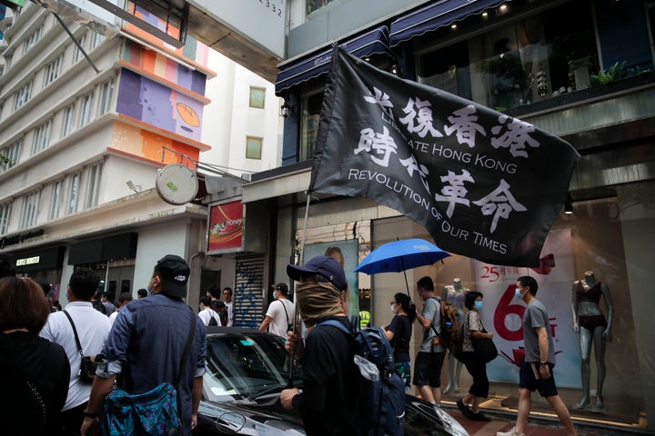 Protesters carry the flag which reads "Liberate Hong Kong, revolution of our time" in Causeway Bay before the annual handover march in Hong Kong, on July 1, 2020. 