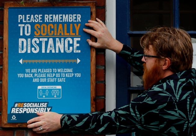Are Kjetil Kolltveit puts up social distancing signs at the Chandos Arms pub in London ahead of 'Super Saturday'