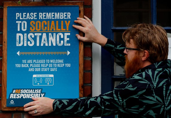 Are Kjetil Kolltveit puts up social distancing signs at the Chandos Arms pub in London ahead of 'Super Saturday'