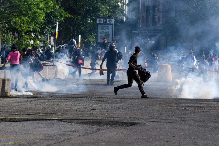Demonstrators are running as Montreal Police uses tear gas during a march against police brutality and racism in Montreal, Canada, on June 7, 2020. 