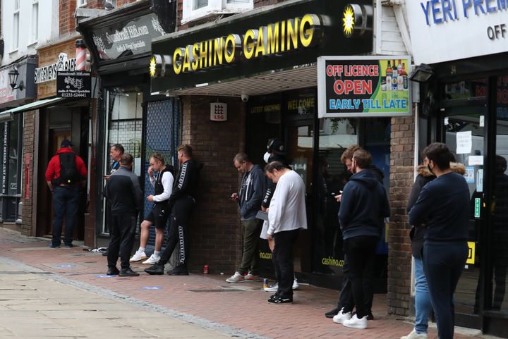 Men wait for a Barbers to open in Ashford, Kent.