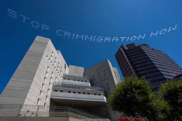 The skytyped phrase, "STOP CRIMMIGRATION NOW," chosen by artist Bobby Salcedo is seen over the LA Field Office during the In Plain Sight day of action on July 3 in Los Angeles. Photo by Ken Gonzales-Day.