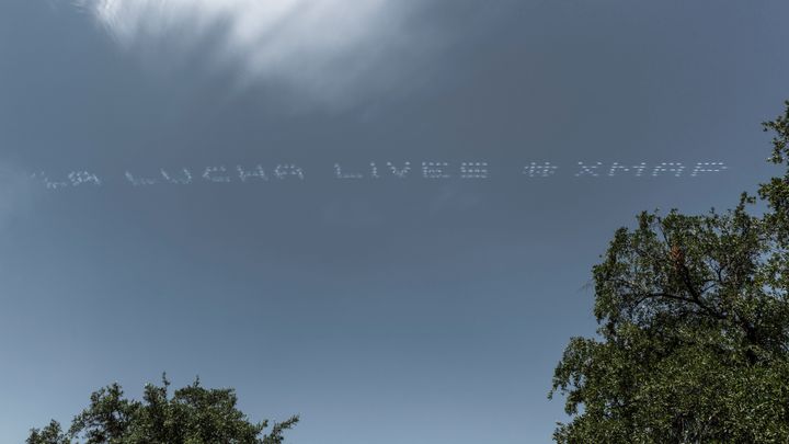 The skytyped phrase "LA LUCHA LIVES," chosen by artist Cruz Ortiz is seen over the Central Texas Detention Facility during th