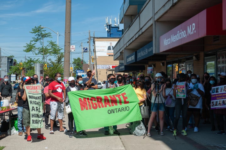 Demonstrators gathered in front of Immigration Minister Marco Mendicino's office in Toronto after the deaths of three migrant workers who contracted COVID-19 to demand full immigration status for all non-permanent residents on Saturday.