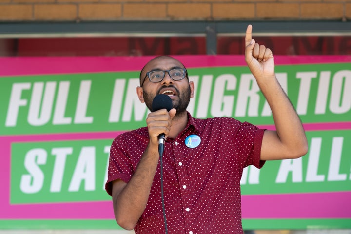 Syed Hussan, executive director of Migrant Workers Alliance for Change, speaks to a crowd gathered in front of Immigration Minister Marco Mendicino's office in Toronto on Saturday.