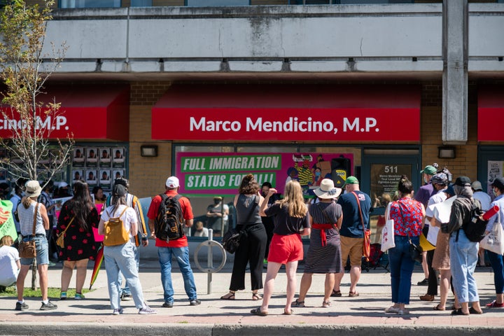 Demonstrators gathered in front of Immigration Minister Marco Mendicino's office in Toronto after the deaths of three migrant workers who contracted COVID-19.