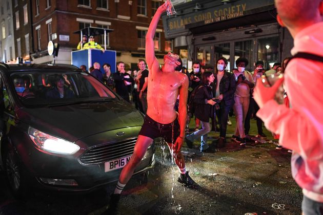 LONDON, ENGLAND - JULY 04: A man is seen pouring water over himself in front of a car in Soho on July 4, 2020 in London, United Kingdom. The UK Government announced that Pubs, Hotels and Restaurants can open from Saturday, July 4th providing they follow guidelines on social distancing and sanitising. (Photo by Peter Summers/Getty Images)