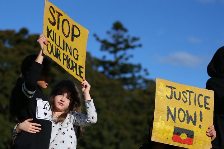 SYDNEY, AUSTRALIA - JULY 05: People hold up signs during a rally against Black Deaths in Custody in The Domain on July 05, 2020 in Sydney, Australia.The rally was organised to protest against Aboriginal and Torres Strait Islander deaths in custody and in solidarity with the global Black Lives Matter movement. (Photo by Don Arnold/Getty Images)