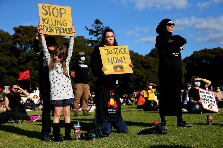 SYDNEY, AUSTRALIA - JULY 05: People hold up signs during a rally against Black Deaths in Custody in The Domain on July 05, 2020 in Sydney, Australia.The rally was organised to protest against Aboriginal and Torres Strait Islander deaths in custody and in solidarity with the global Black Lives Matter movement. (Photo by Don Arnold/Getty Images)