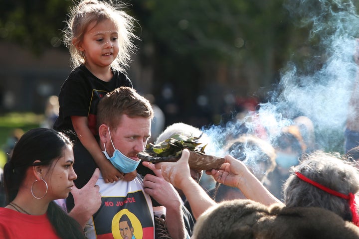 SYDNEY, AUSTRALIA - JULY 05: Aboriginal elders conduct a traditional smoking ceremony during a rally against Aboriginal and Torres Strait Islander deaths in custody in The Domain on July 05, 2020 in Sydney, Australia. Since the Royal Commission into Aboriginal deaths in custody ended in 1991 there have been over 400 deaths. Rallies have been organised across the country in solidarity with the global Black Lives Matter movement. (Photo by Lisa Maree Williams/Getty Images)