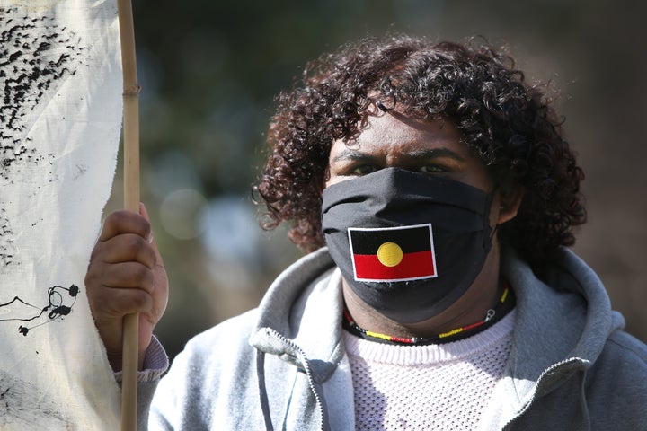 SYDNEY, AUSTRALIA - JULY 05: A protester wears a face mask depicting the Aboriginal Flag during a rally against Aboriginal and Torres Strait Islander deaths in custody in The Domain on July 05, 2020 in Sydney, Australia. Since the Royal Commission into Aboriginal deaths in custody ended in 1991 there have been over 400 deaths. Rallies have been organised across the country in solidarity with the global Black Lives Matter movement. (Photo by Lisa Maree Williams/Getty Images)