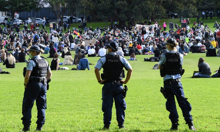 SYDNEY, AUSTRALIA - JULY 05: Police wear face masks as they watch people gather in the Domain on July 05, 2020 in Sydney, Australia. The rally was organised to protest against Aboriginal and Torres Strait Islander deaths in custody and in solidarity with the global Black Lives Matter movement. (Photo by James D. Morgan/Getty Images)