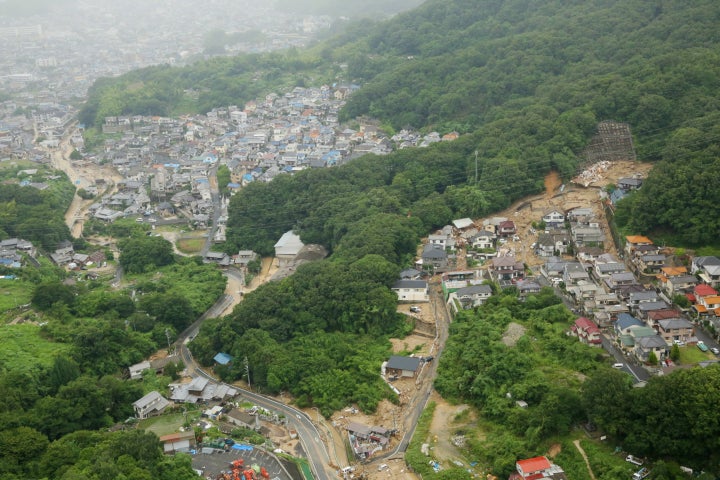 土砂災害で多数の犠牲者が出た広島市安芸区・矢野東地区。土砂に押し流された住宅街（右）と冠水した道路（左奥）＝2018年7月7日、広島市安芸区矢野東