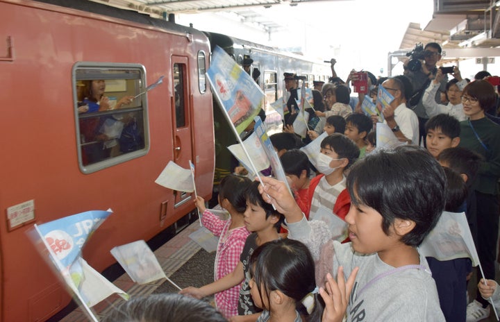 西日本豪雨で被災し、不通が続いていたJR芸備線が、2019年10月23日に全線運転を再開。列車を見送る広島市立尾長小学校の児童ら＝2019年10月23日、広島駅