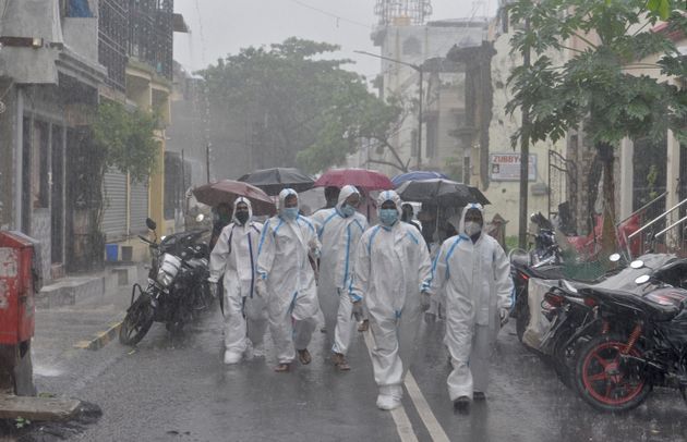 Γιατροί και νοσηλευτές σε γειτονιά στο Μπουμπάι και υπό βροχή για να εξετάσουν κατοίκους πόρτα-πόρτα (Ινδία) 