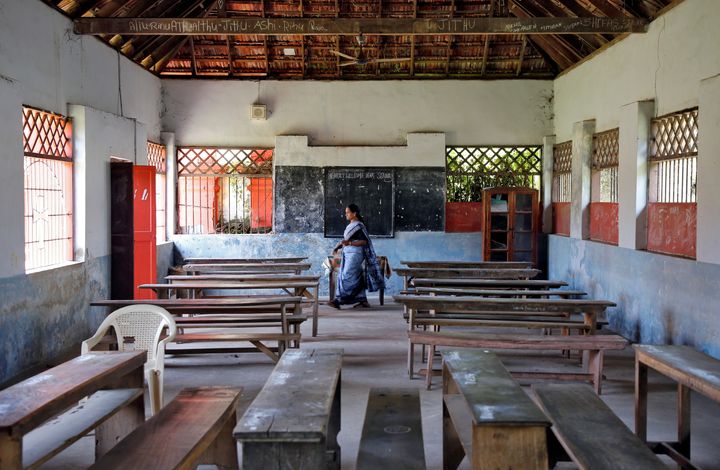 A staff member walks inside an empty classroom of a school after Kerala government ordered the closure of schools across the state, March 12, 2020. 