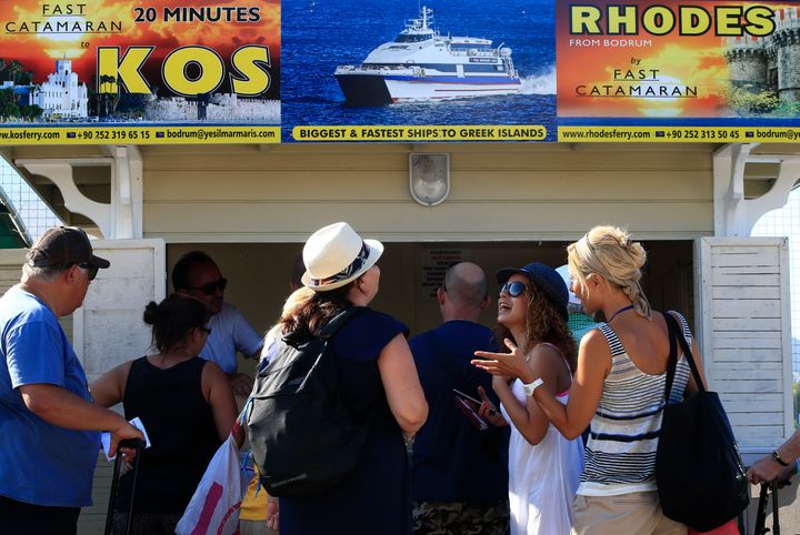 Tουρίστες στην Τουρκία έτοιμοι να αγοράσουν εισιτήρια με προορισμό τα ελληνικά νησιά στο Αιγαίο, αναχωρώντας από την Αλικαρνασό (Μπόντρουμ) το καλοκαίρι του 2015. Φωτογραφία αρχείου.(AP Photo/Lefteris Pitarakis)