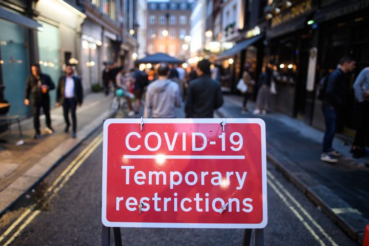 People eat and drink oudoors in Soho, London, as coronavirus lockdown restrictions are eased across England
