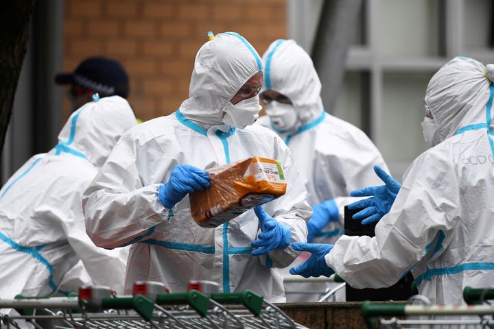Firefighters dressed in personal protective equipment prepare to distribute food throughout a public housing tower, locked down in response to an outbreak of the coronavirus disease (COVID-19), in Melbourne, Australia, July 7, 2020. 