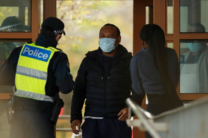 MELBOURNE, AUSTRALIA - JULY 07: People speak with police at the entrance to one of the public housing towers in Kensington on July 07, 2020 in Melbourne, Australia. 