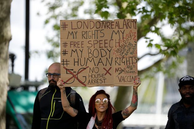 A woman holds up a placard at a coronavirus anti-lockdown, anti-vaccine, anti-5G and pro-freedom protest in London.