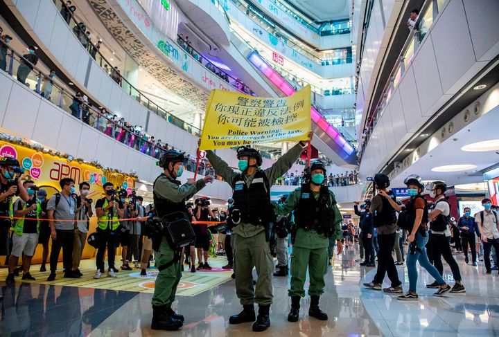 Riot police hold up a warning flag during a demonstration in a mall in Hong Kong on Monday, in response to a new national security law introduced in the city which makes political views, slogans and signs advocating Hong Kong's independence or liberation illegal.