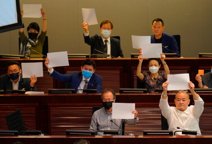 Pro-democracy lawmakers raise white papers to protest during a meeting to discuss the new national security law at the Legisl