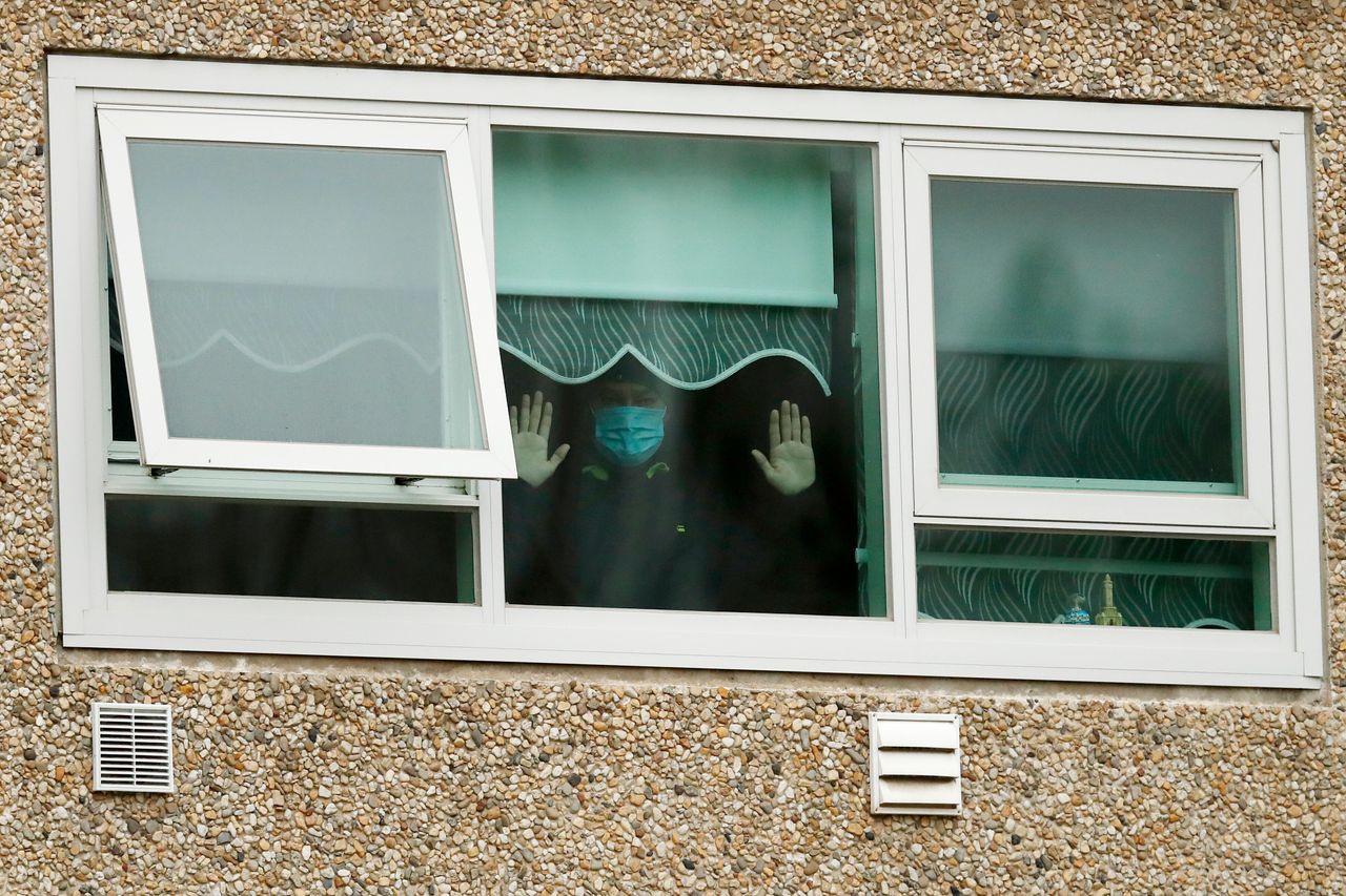A man looks out the window of the Flemington Towers government housing complex on July 6 in Melbourne, Australia. Nine public housing estates were under mandatory lockdown and two additional suburbs remained under stay-at-home orders as authorities worked to stop further COVID-19 outbreaks in the city. The only people allowed in and out were those providing essential services.