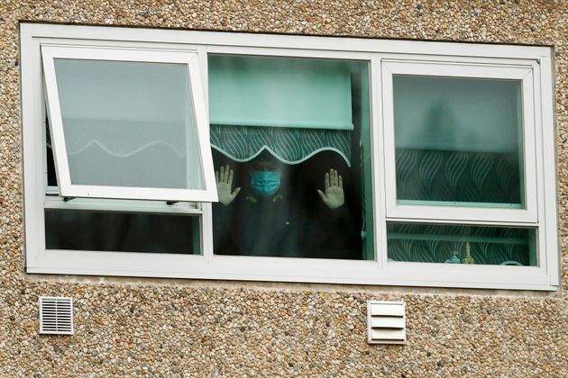 A man looking out a window of the locked-down housing complex on Monday in Melbourne. 