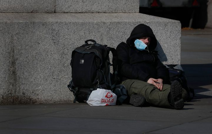 A man sleeps on the pavement in Westminster in London, British people have been told to stay home to prevent the spread of the new coronavirus, Friday, March 27, 2020. Local Authorities in England have been asked by the prime minister's homelessness advisor to house all homeless people by the weekend, to help stop the spread of COVID-19. (AP Photo/Frank Augstein)
