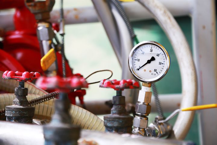 Pressure gauge using measure the pressure in production process. Worker or Operator monitoring oil and gas process by the gauge for routine record and analysis oil and gas production process.