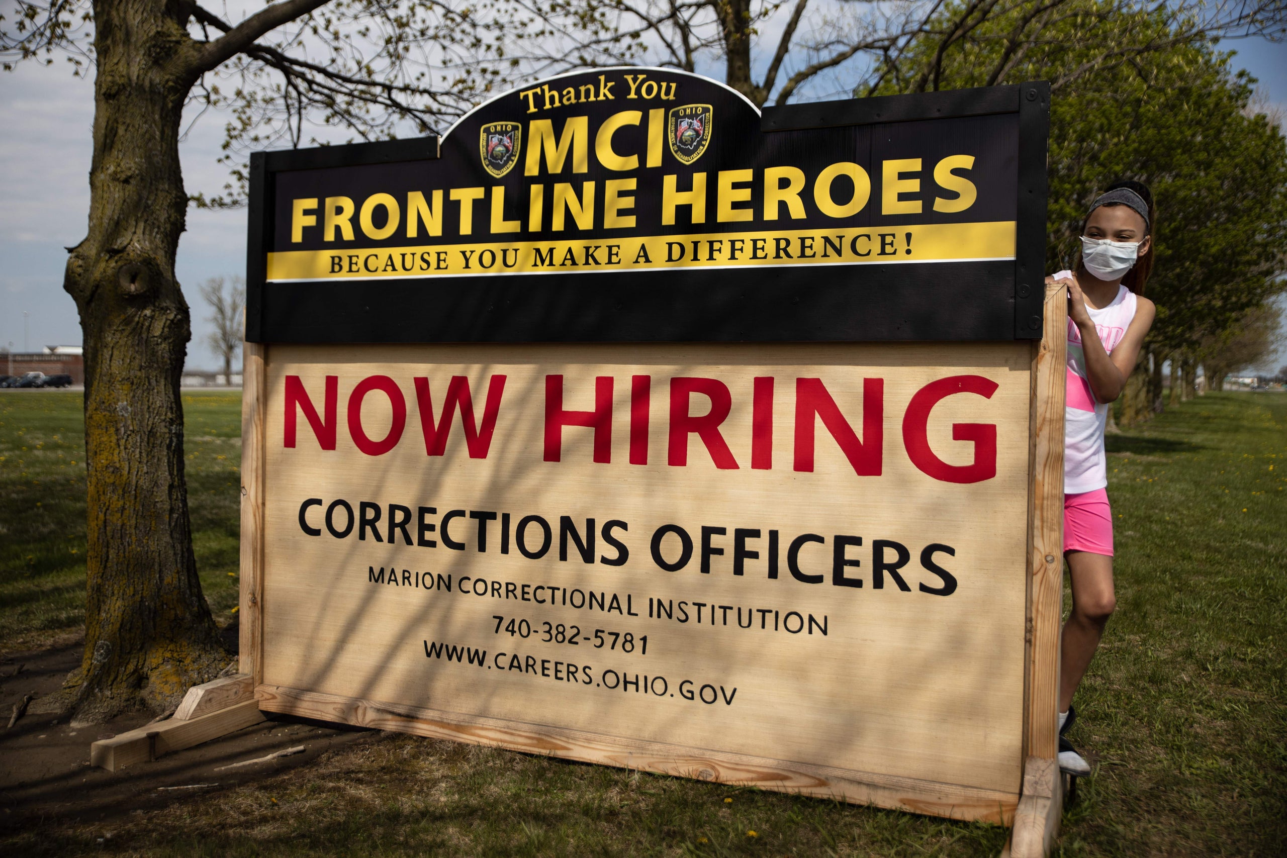 A young girl stands behind a Marion Correctional Institution sign during a May 2 protest to increase public awareness of the 