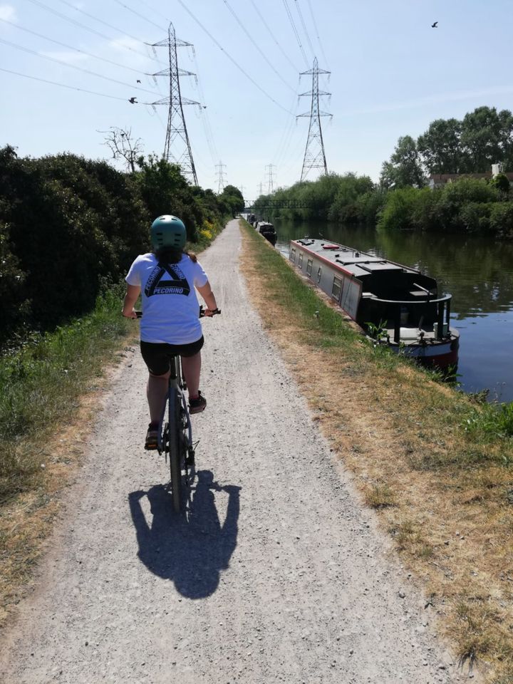 Isabelle Aron cycling along a canal