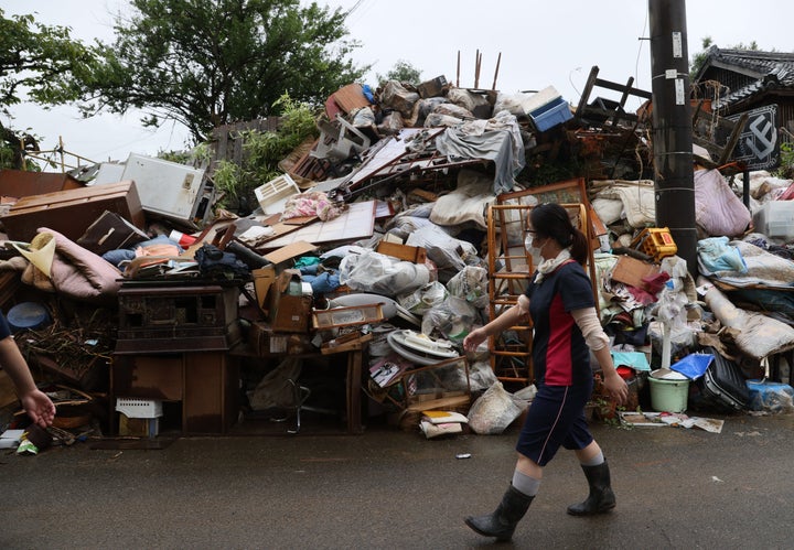 大雨による浸水被害を受け、道路脇に積み上げられた災害ごみ＝9日午前、熊本県人吉市 