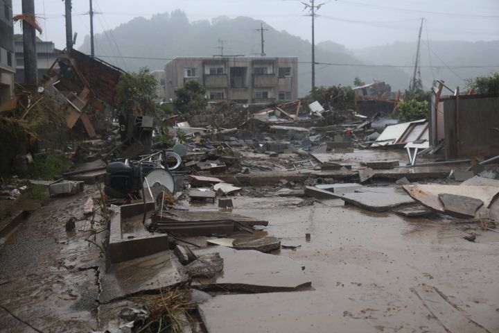 大雨による浸水被害などで押し流された建物（左奥）や家財＝5日午後、熊本県人吉市