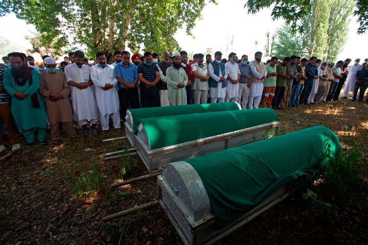 Relatives and BJP workers offer funeral prayers in front of the coffins of BJP leader Waseem Bari, his father and his brother, in Kashmir on 9 July 9, 2020.