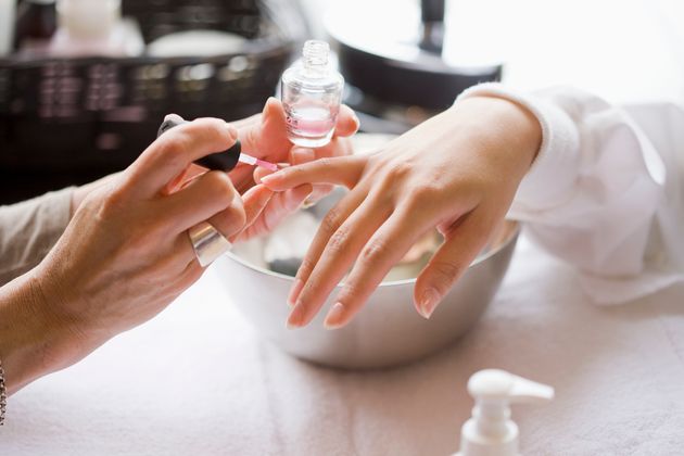 Manicurist applying nail polish