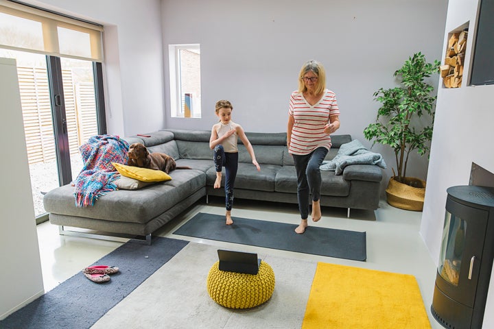 Senior lady exercising indoors with her granddaughter