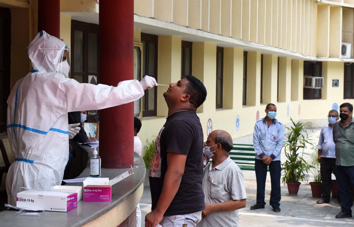 A health worker collects a swab sample for the Rapid Antigen Test for Covid-19 at Happy School at Daryaganj on July 3, 2020 in New Delhi.