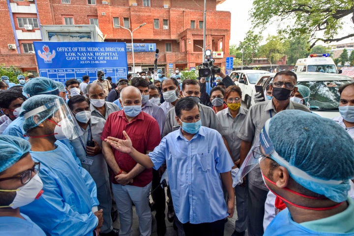 Delhi Chief Minister Arvind Kejriwal and Deputy CM Manish Sisodia talk to the medical workers at Lok Nayak Jai Prakash Narayan Hospital on June 25, 2020 in New Delhi.