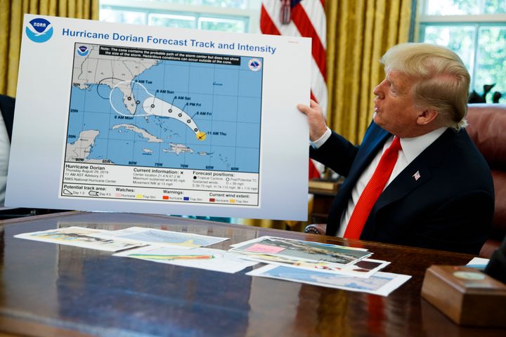 President Donald Trump holds a chart on Sept. 4, 2019, as he talks with reporters after receiving a briefing on Hurricane Dorian.