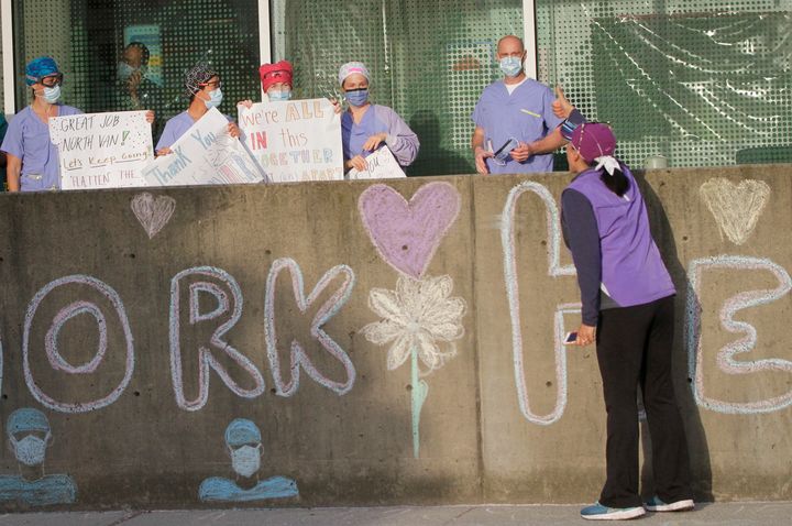 A resident shows appreciation to medical workers fighting on the front lines of the COVID-19 pandemic outside Lions Gate Hospital in Vancouver on April 17, 2020. 