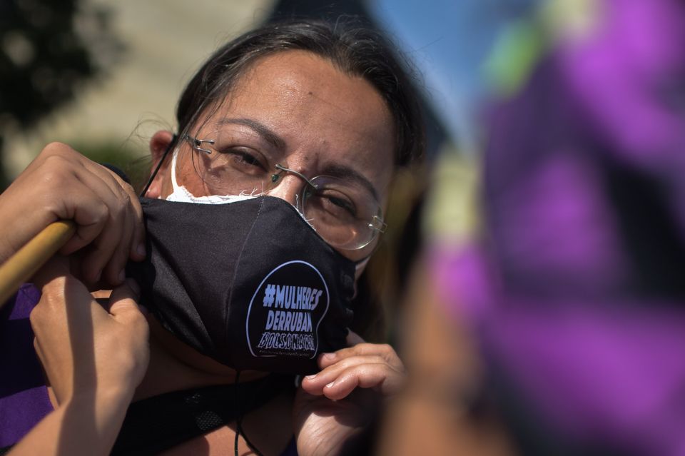 Mulher utiliza máscara de proteção em protesto na Esplanada dos Ministérios,...