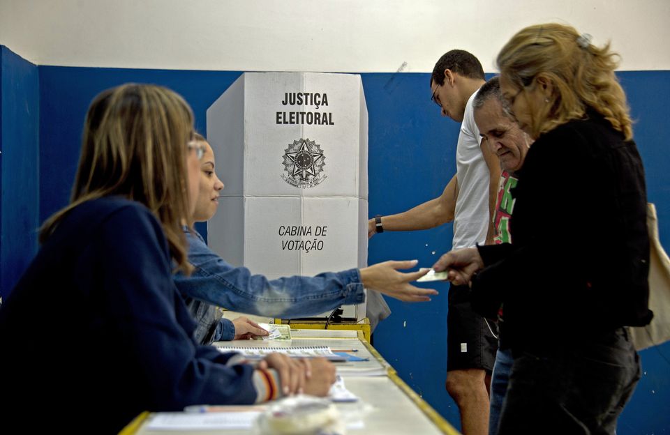 Eleitores votam no Colégio Municipal Ayrton Senna, ao lado da favela da Rocinha, no Rio de Janeiro,...