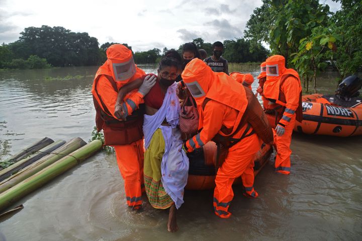 NDRF personnel carry a sick woman during a rescue operation in a flood affected area due to monsoon rains, in Pathsala of Barpeta district in Assam on July 12. 
